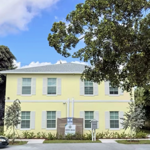 Exterior of quadplex investment property in Riviera Beach, Florida with gated front and tile roof